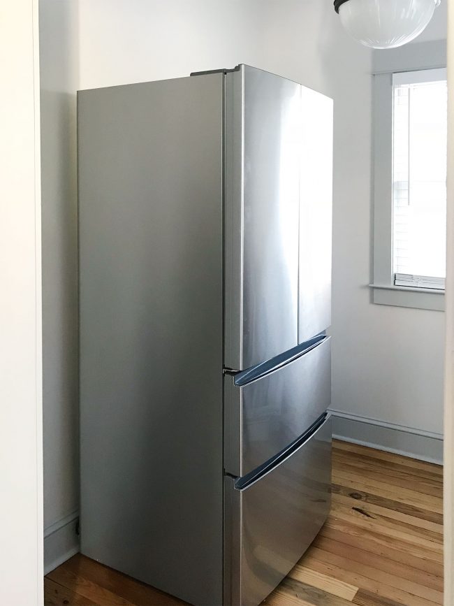 apartment size refrigerator in walk in pantry before shelves