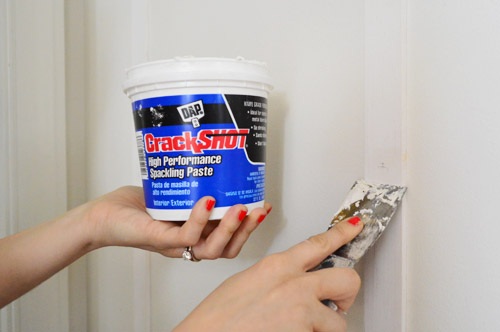 applying DAP CrackShot High Performance Spackling Paste to fill nail holes in wood DIY project