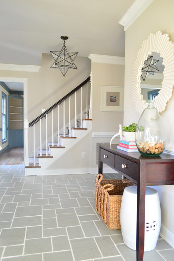 foyer entryway with gray slate tile floor and clean white grout lines including pretty mirror and star pendant light