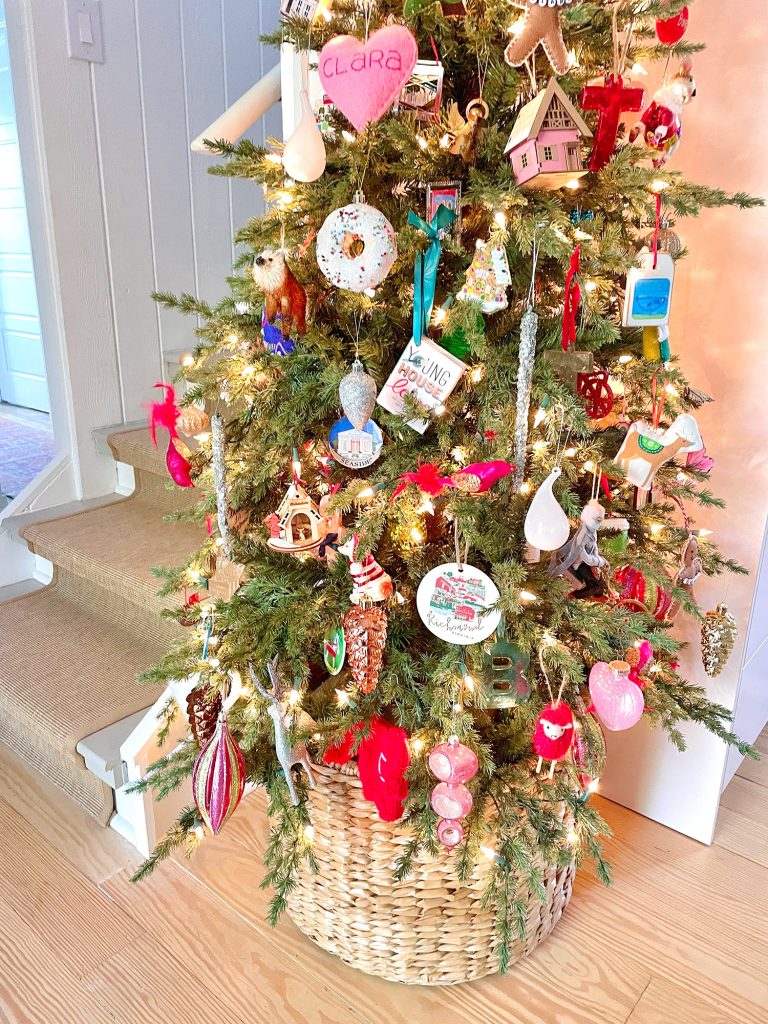 Detail of ornaments on narrow Christmas tree in kitchen in wicker basket