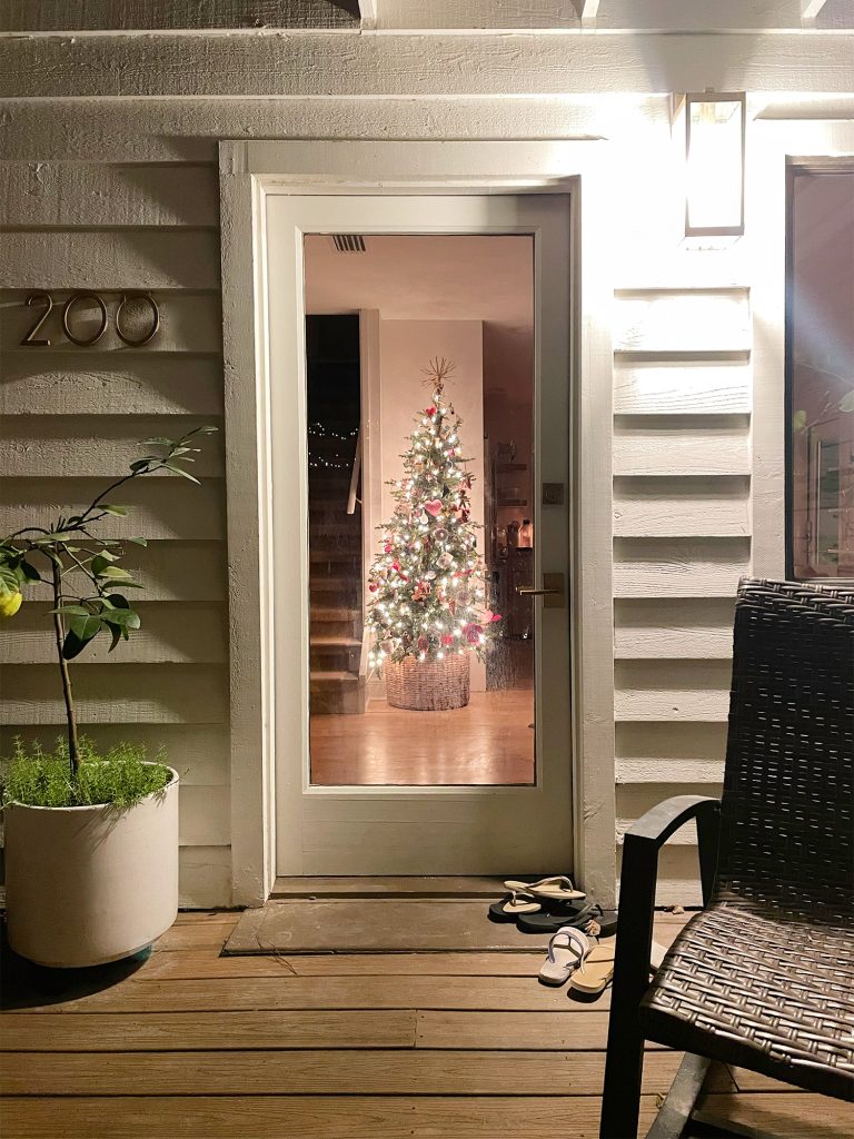 View of Christmas Tree in kitchen through front door at night