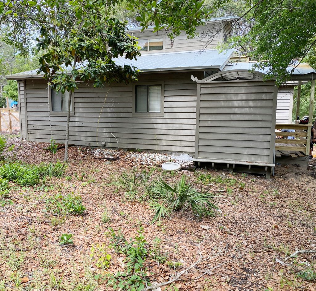 Before photo of house brown with same empty backyard