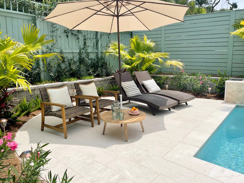 Round pool patio area surrounded by tropical plantings Chinese palms oleander jasmine stonecrop foxtail ferns