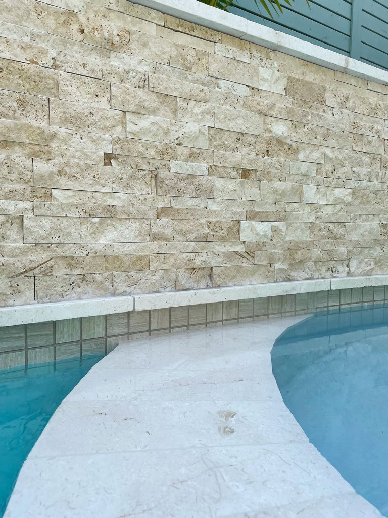 Detail photo of accent wall stacked natural stone tile and neutral waterline tile