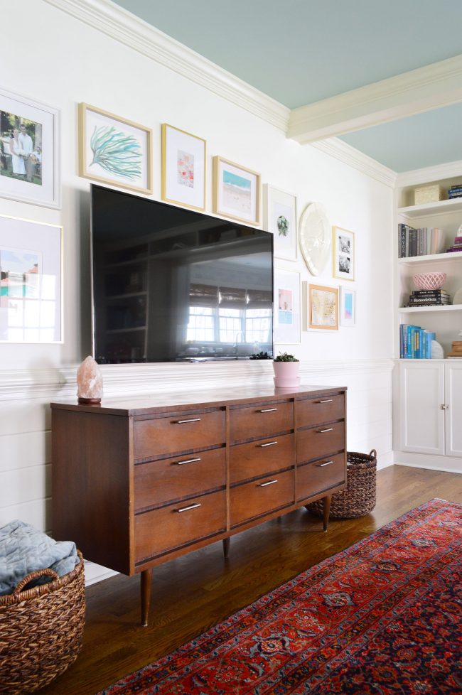 television mounted to the wall with a picture frame gallery surrounding it